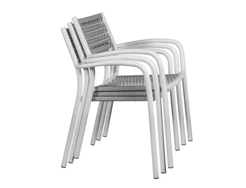 Imagen de unas sillas apilonadas de diseño moderno con estructura y patas en color blanco. Presenta un asiento y respaldo con tejido con un patrón geométrico de cuadrícula en color gris que contrasta con el fondo neutro.