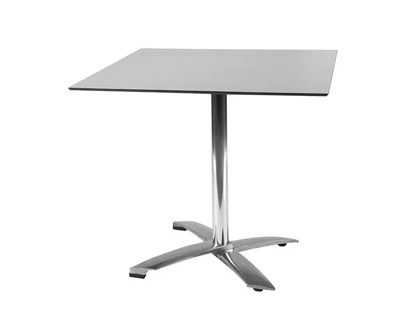 Imagen de una mesa moderna con superficie cuadrada de color gris claro y base central de metal cromado con cuatro patas inclinadas. La mesa tiene un diseño minimalista y contemporáneo, ideal para bares o restaurantes modernos