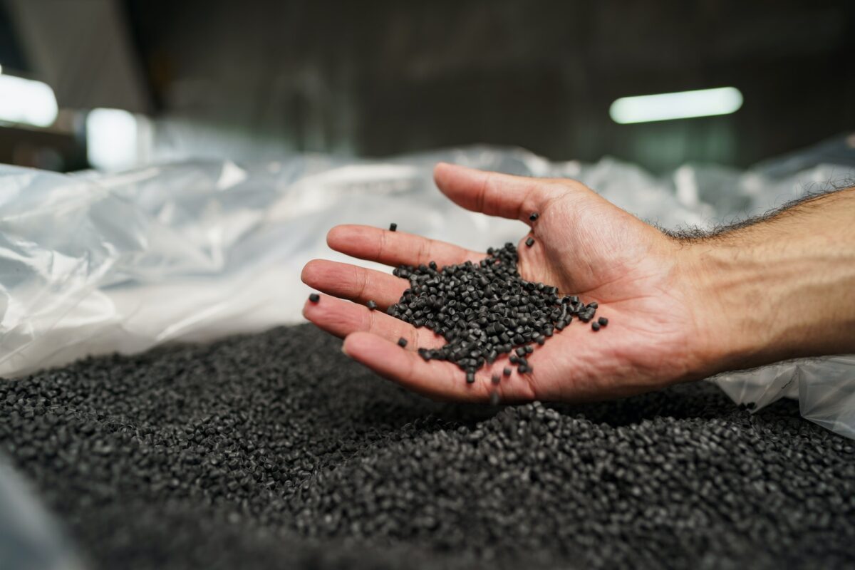 Close up of male hand holding plastic polymer granules